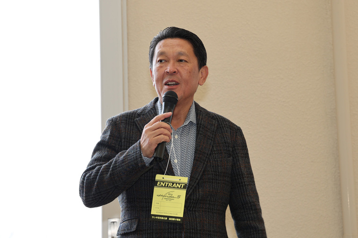 開会式でスピーチするホンダの青山真二代表執行役副社長。首から提げた「ENTRANT」パスのとおり、自身の所有する「S800クーペ」を携えて参加した。