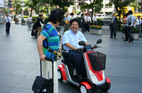 やはりこのデザインは気になる？　通りがかりの女性に話かけられる、デザイン担当の山岸政彦氏。フィットのチーフデザイナーとしても知られる。