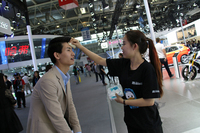 北京モーターショー初日の気温は30度。汗を拭いてもらうMINIの男性コンパニオン。
