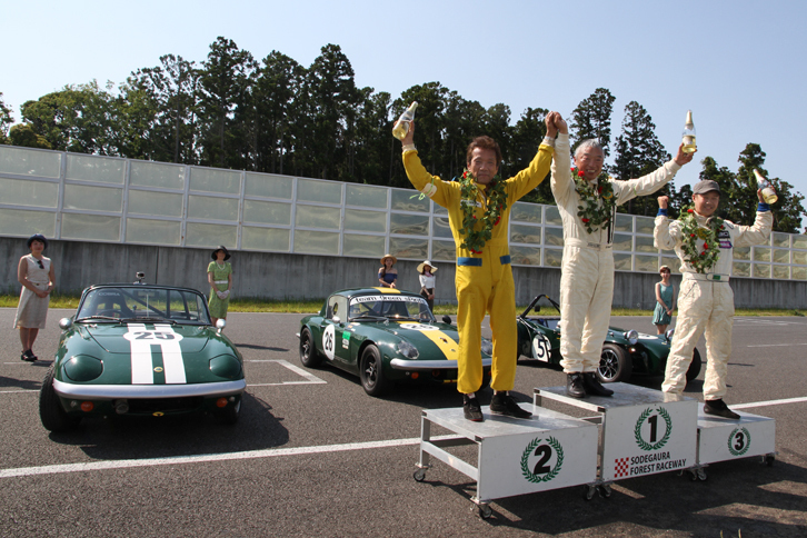 各レースの表彰後、コース上で暫定表彰を実施。総合1～3位はグリッドレディーからレイを贈られ、シャンパンファイトに興じる。エバーグリーンカップで、2台の「エラン」に続く総合3位には1969年「ロータス・セブンSr3」が入り、ロータスが表彰台を独占した。