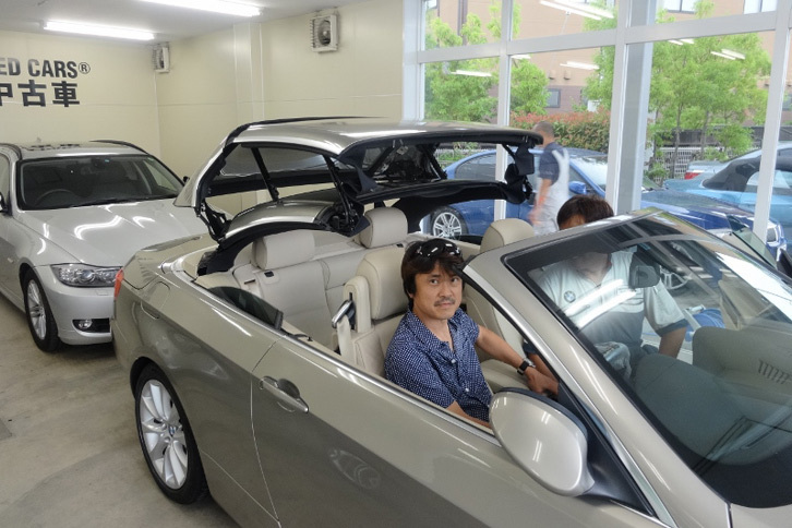 BMWアプルーブドカー・センターにて、「BMW 335iカブリオレ」のルーフを確認中の筆者。