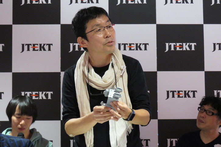 企画の概要を説明する多摩美術大学の久保田晃弘教授。イベント名であり、企画のテーマでもある「MOBIVERSE」とは、モビリティーとユニバース（宇宙）を組み合わせた造語である。