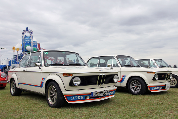 2台並んだ欧州初の市販ターボ車である1974年「BMW 2002ターボ」。手前は並行輸入された欧州仕様で、奥は当時のインポーターだったバルコム貿易による正規輸入車。リベット留めされたFRP製オーバーフェンダーが認可されなかったため、スチール製のものを溶接後、パテ埋めしている。