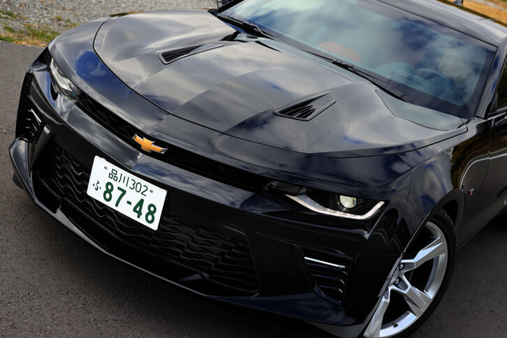 V8モデルの特徴である、フードベントが開けられたボンネット。バンパーの意匠やフロントグリルの模様なども、直4モデルとは異なっている。