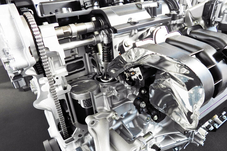 1.5リッターガソリンエンジンのカット模型。燃料供給システムには筒内直接噴射を採用。新設計の吸気システム（展示ではアルミテープで隠されている）や燃焼室形状、冷却システムの採用により、燃焼効率の向上が図られている。