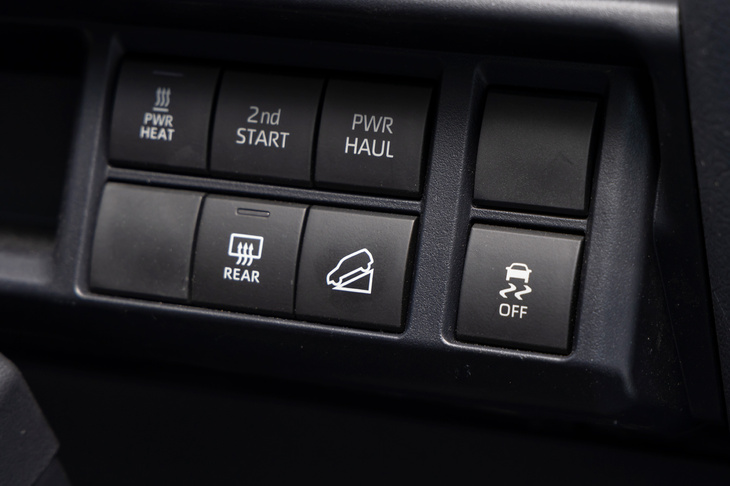 ダッシュボードに備わるダウンヒルアシストのスイッチ（写真中央）。同システムにブレーキ制御式のアクティブトラクションコントロールと、「ランクル“70”」にもいよいよ電制のアシスト機構が備わるようになった。