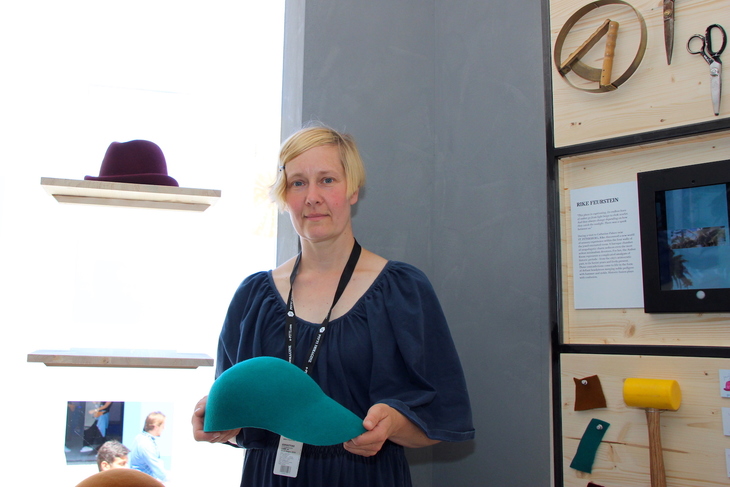 エメラルド色のモダンベースキャップを手にした、デザイナーのリケ・フォイヤシュタイン。作品のインスピレーションは、ロシア旅行で訪れたサンクト・ペテルブルク近郊エカテリーナ宮殿の琥珀（こはく）の間から受けたという。