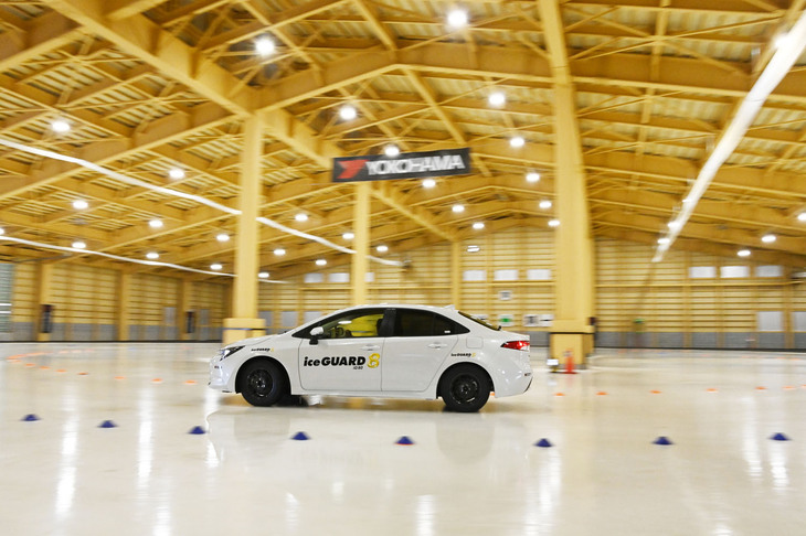 横浜ゴムの「北海道タイヤテストセンター」内に建てられた屋内氷盤旋回試験場。氷盤面積は1960平方メートルで、旋回半径10～22ｍまでの試験が可能だ。今回は「アイスガード7」と「アイスガード8」をいずれも「トヨタ・カローラ」に装着し、旋回性能の差を確かめることができた。