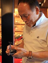 佐藤さんが持つのはレース用エランのねじ切れたカムシャフトと曲がったバルブ。知り合いが作った“記念の”オブジェ。