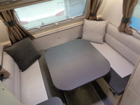 フロント側にあるダイニングテーブルとシート。小ぶりなトレーラーながらU字型ダイネットが備わる。