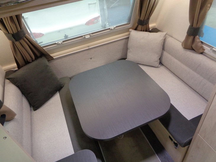 フロント側にあるダイニングテーブルとシート。小ぶりなトレーラーながらU字型ダイネットが備わる。
