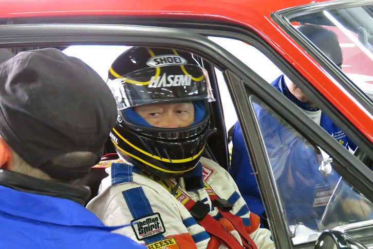 「ダットサン・サニーエクセレント クーペ」に乗り込み、同車のレストアを手がけた日産名車再生クラブのメンバーから、走行に関する注意を聞くドライバーの長谷見昌弘氏。