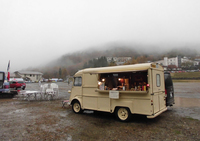 会場では、自動車関連グッズの販売や、食事のケータリングサービスも行われる。写真は、参加車両もまばらな早朝のワンシーン。