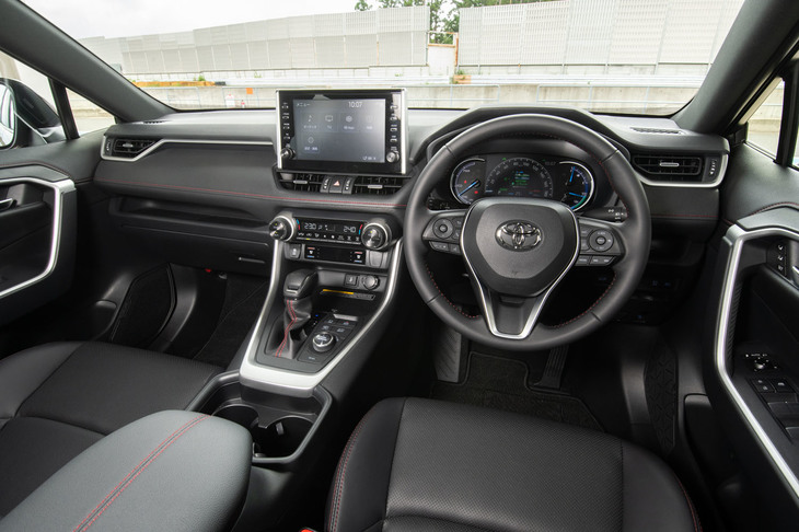 “エコカー”らしからぬ、赤いステッチが目を引くインテリア。空調には使用時の電力消費を抑えるべく、ヒートポンプエアコンを用いている。