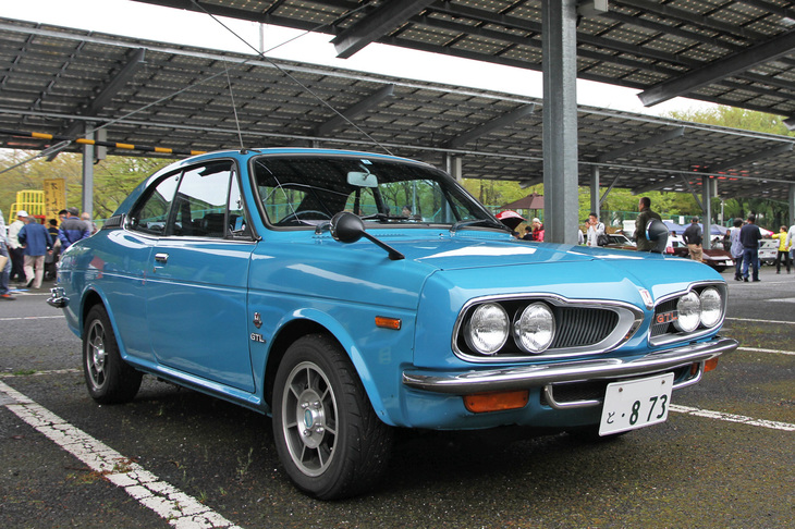 1972年「ホンダ1300クーペGTL」。H1300クーペは1971年にマイナーチェンジされ、シングルキャブ版がゴールデンシリーズ、4キャブ版がダイナミックシリーズと呼ばれるようになった。ゴールデンシリーズは1970年に先行してフェイスリフトされたセダンと共通のおとなしい顔つきとなり、従来からの2分割グリルを持つダイナミックシリーズは、このGTLのみとなった。この個体は、ハヤシストリートのアルミホイールを除き、ブルーの塗装も含めオリジナルのままという希少な残存車両である。ちなみにH1300シリーズ全体の販売台数はおよそ3年間で約10万台と、ホンダのもくろみには遠かったものの、想像するほど悲観的な数字ではない。とはいうものの皮算用が大きかっただけに量産効果が得られず、「1台売れるごとに5万円の赤字」と言われたほど製造コストがかさんでしまい、ホンダの経営を圧迫した。
