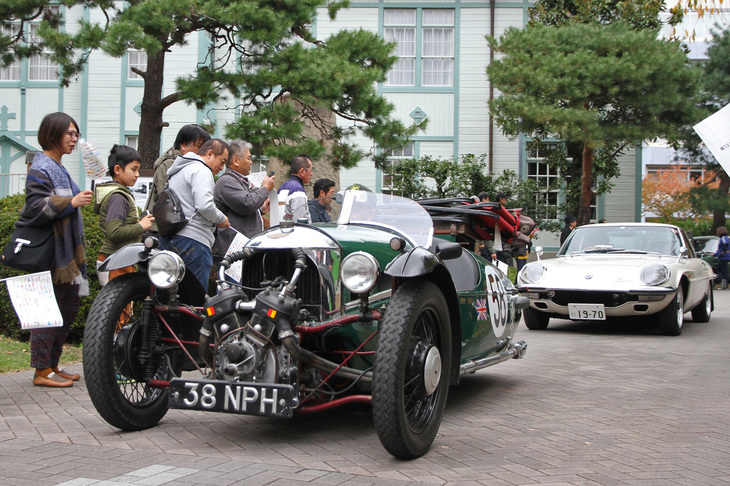 マチレスの二輪用Vツイン990ccエンジンを前端に積んだ、1933年「モーガン・スリーホイーラー」。その名のとおり前二輪、後ろ一輪の三輪スポーツカー。後ろに続くのは1970年「マツダ・コスモスポーツ」。