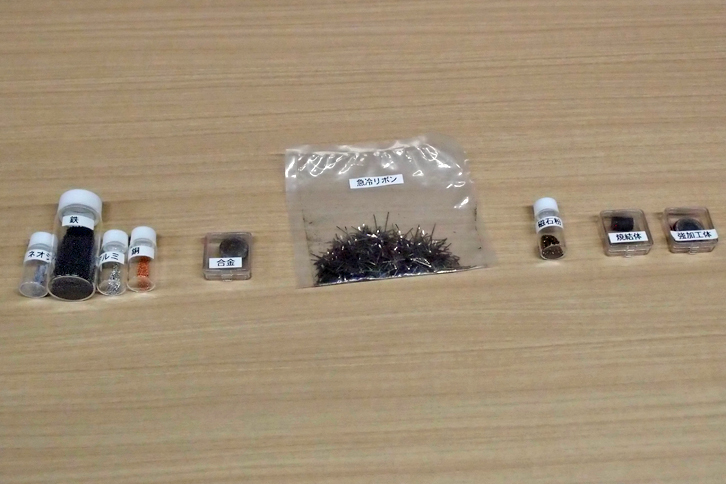 新開発磁石と、その製造過程を示すサンプル。写真で一番左に見えるのが、ネオジムである。