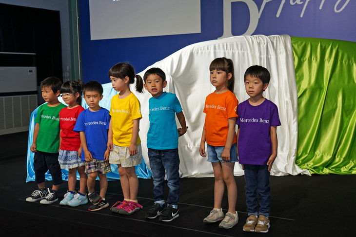 ステージに上がったのはかわいらしい7人の子どもたち。色違いのTシャツにはそれぞれ「Mercedes-Benz」ロゴがプリントされている。