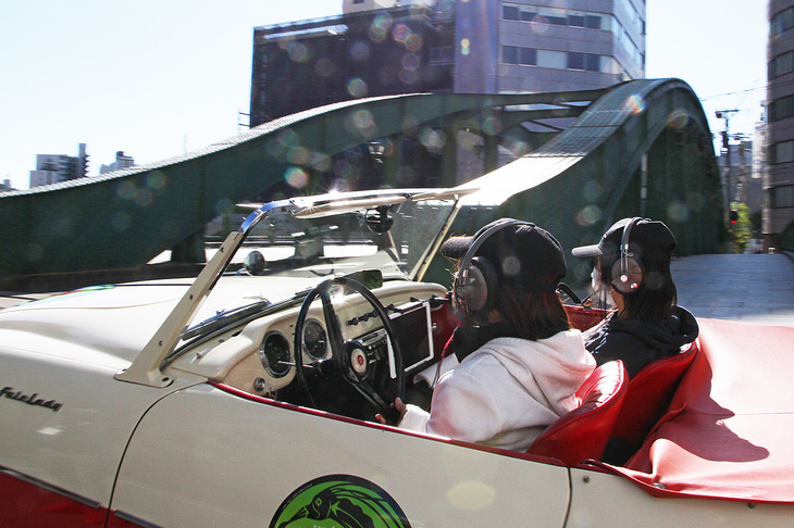 おみやげを受け取って柳橋に向かう、女性ペアがドライブする1960年「ダットサン・フェアレディSPL212」。初めてフェアレディの名を与えられた対米輸出専用車。