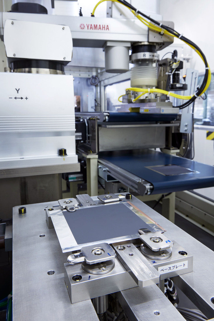 スラリーを塗って加圧、裁断した正極と、負極を積層する。負極の表面にはデンドライトの成長を抑制するため、特殊なコーティングが施されている。