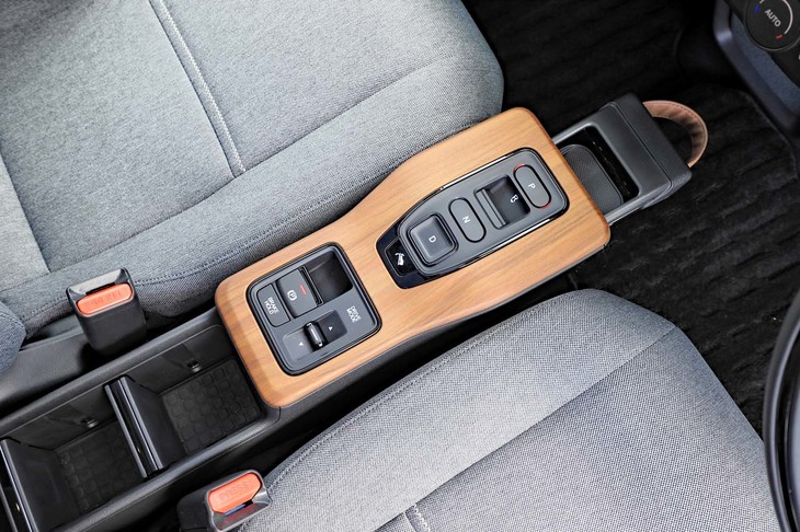 センターコンソールにはボタン式のシフトセレクターなどが並ぶ。前方には引き出して使うカップホルダーが隠されている。