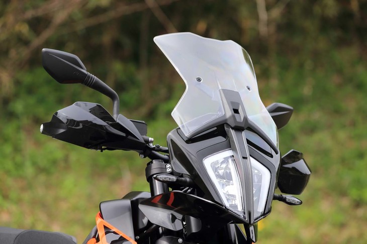 フロントまわりは、KTMのアイコンである縦長のヘッドランプが特徴。ウインドシールドはロングタイプ（写真）とショートタイプの2種類が用意されており、ステーを調節することで高さを2段階に変えられる（調節幅は40mm）。