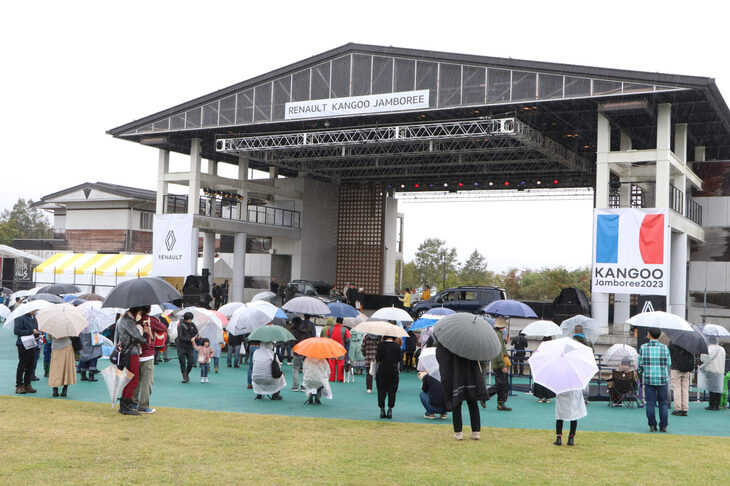 例年なら日よけのための小型テントであふれるステージ前も、今年は傘でにぎわう状態に。雨のために座ることができず、スタンディングでのステージ観覧となったが、常に多くのファンであふれていた。