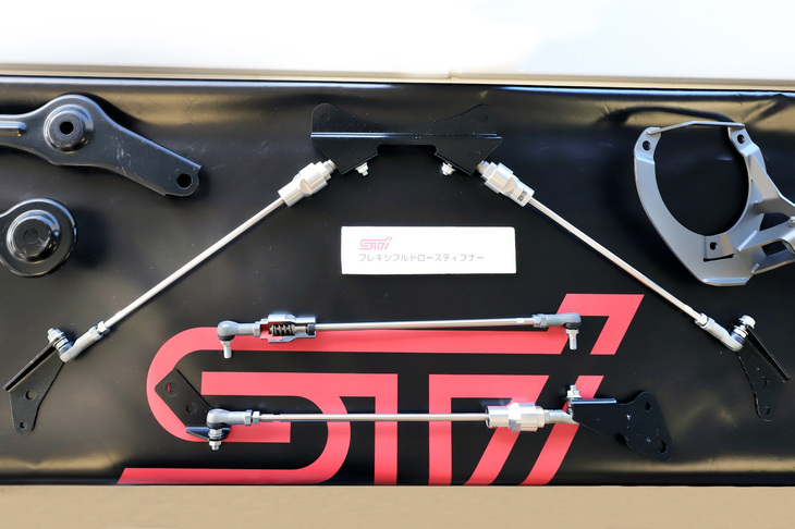 車体とクロスメンバー間に設置するフレキシブルドロースティフナー。スプリングによって適度なテンションをかけ、走行中のシャシーのしなりを補正する。