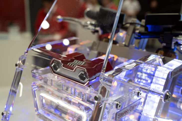 2021年1月に誕生した日立アステモは、前回にあたる2021年のEICMAで初出展。そのときは先進運転支援システムなどを開発する日立オートモーティブシステムズ、燃料供給システム電子制御システムのケーヒン、サスペンションのショーワ、ブレーキのニッシンが統合して初めてのEICMAだったこともあり、それぞれの最先端技術やプロダクトの紹介を行っていた。そして今回は、その4ブランドが集まったことで実現可能となった現在開発中のADAS（先進運転支援システム）や、小型電動バイク向けのシステムソリューションを展示した。新たなADASは、現在市販されている二輪用ADASがレーダーを使っているのに対し、小型ステレオカメラを使用。それによって路面状況や道路環境をより高い精度で判別することができるという。また、そこで得たデータをもとにサスペンションやブレーキ、出力特性を一元的に管理および変化させることで、安全性を高める研究も行っているとのことだ。また、これらのシステムや機能を簡略化した、小排気量二輪車への搭載システムも展示されていた。