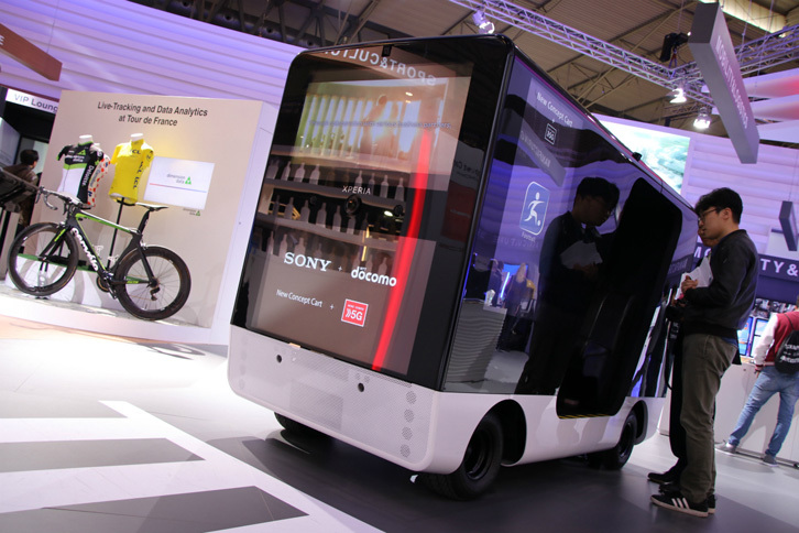 NTTドコモによる「New Concept Cart」。乗員は、フロントウィンドウ越しの風景ではなく、室内の4Kカメラ映像を見て操縦する。一方で走行中は、車外のディスプレイには広告が投影される。