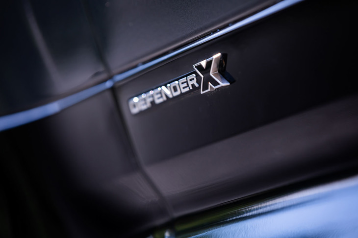 左右のフロントドアに貼られた「DEFENDER X」のエンブレム。スターライトサテンクロームやグロスブラックといった光沢のあるブラックパーツが採用されるのも同モデルの特徴だ。