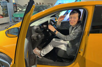 身長約166cmの筆者が、運転席に一般的な運転姿勢で座ったところ。右手で示している程度のヘッドルームが確保されている。