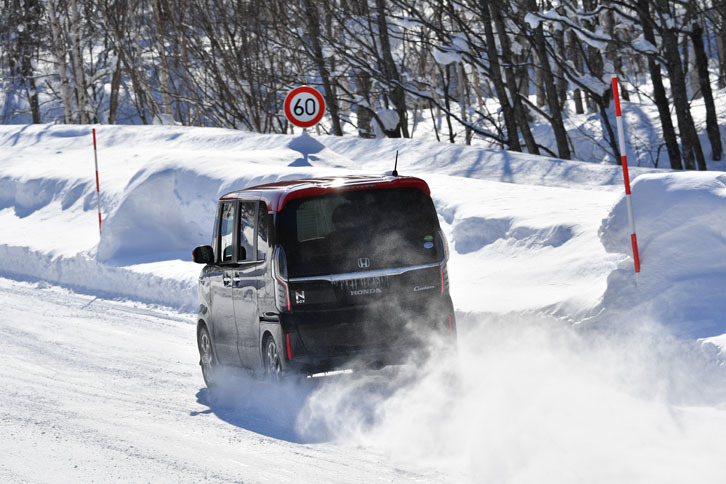 雪煙を上げながらEU郊外コースを行く「N-BOXカスタム G・LターボHonda SENSING」。