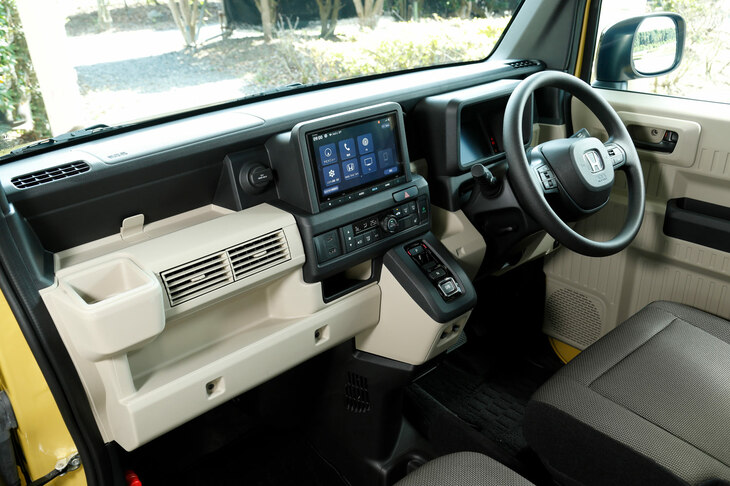 「N-VAN e： FUN」のインストゥルメントパネルまわり。インテリアカラーは、e： FUNはベージュ、その他の仕様がグレー。1人乗りおよびタンデムシートの2人乗り仕様では、助手席側ダッシュボードの収納類を撤去し、より大きな室内長を実現している。