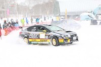 ラリードライバーの鎌田卓麻選手によるデモランの様子。リアタイヤが巻き上げた雪が、クルマのすぐ背後にいる観客にかかっている。