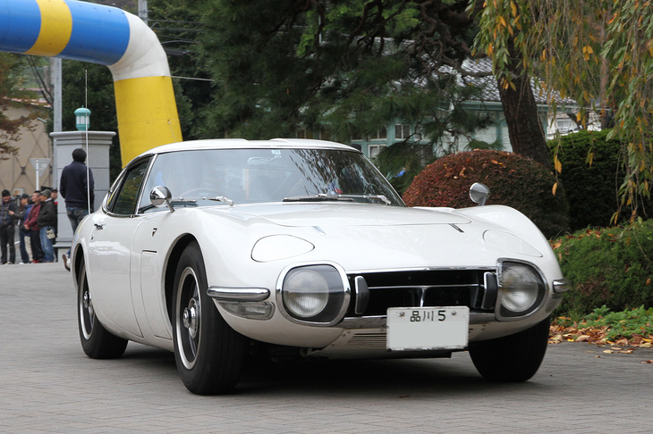 会場入りする1967年「トヨタ2000GT」。新車以来の「品川5」ナンバーを持つ個体を譲り受けた現オーナーが、全バラにしてからボディーワークを除き独力でレストアしたという。