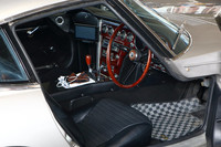 美しいウッドのステアリングホイールやダッシュパネルが目を引くインテリア。乗降の際に足を抜き差ししやすいよう、ドアはフロントフェンダーパネルに食い込むようにデザインされている。