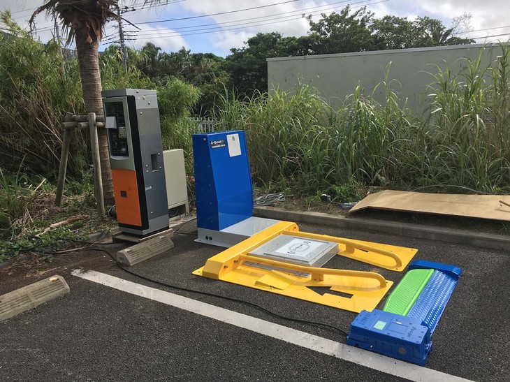 非接触充電用チャージングドック。送電ユニットを包むように、左右両輪をガイドする黄色いパイプがある。