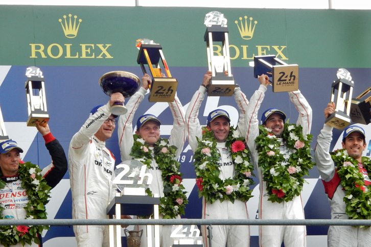 最後の逆転劇で勝利を手にした、No.2 ポルシェ919 ハイブリッドのドライバーたち（写真中央）。ポルシェはルマン2連覇を達成した。（photo=Motoko Shimamura）
	 