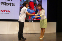 記者会見にて、Hondaウエルカムプラザ青山のスタッフから花束を渡される佐藤選手。