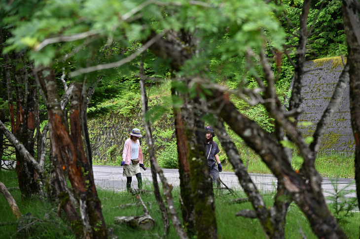 道端でゴミを集める2人。空き缶を手にしているのが確認できる。