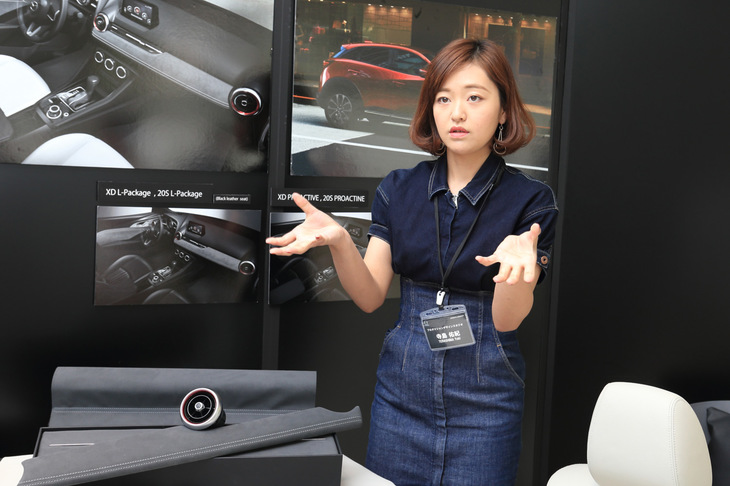 寺島さんと、「Lパッケージ」のインストゥルメントパネルに使用されるグレーのスエード素材。寺島さんいわく「明度についてすごく悩んだ」とのこと。