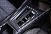 短いレバー形状が特徴となるバイワイヤ式のシフトセレクター。センターコンソールパネルの一番奥に、シルバー色で差異化されたエンジンスタート／ストップスイッチを配置する。センターコンソール奥には、「スマートフォンワイヤレスチャージング」の充電スペースが標準装備されている。