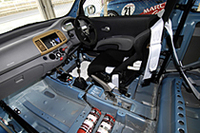 インテリアはスパルタン。内張ははがされ、フルバケットシート、4点式シートベルト、ロールケージ、消化器などの安全装備が備わる。