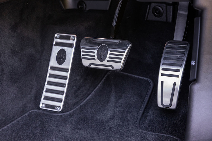 「マセラティ・ギブリ ハイブリッド グランスポーツ」のペダルはアルミ製。ブレーキペダル（中央）とフットレスト（左）の表面には、マセラティのエンブレムをかたどったゴムのすべり止めが備わる。