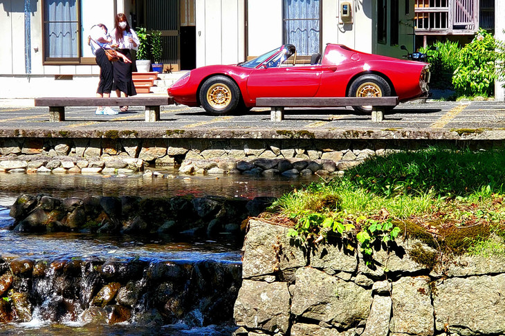 交流広場の堰（せき）のそばにたたずむ「ディーノ246GTS」。バンパーレスもきれいに処理し、レストアもキリッとした仕上げの良い個体であった。