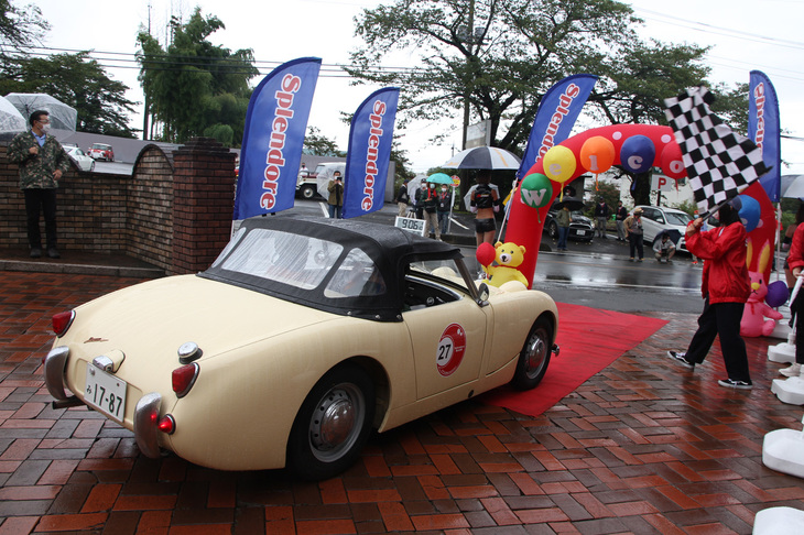 スタート地点を会場側から見た図。なぜかチェッカードフラッグを振られてスタートしていくのは、通称“カニ目”こと1959年「オースチン・ヒーレー スプライトMk1」。