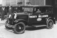 工場からラインオフする「フォードA型」をドライブするヘンリー・フォード。