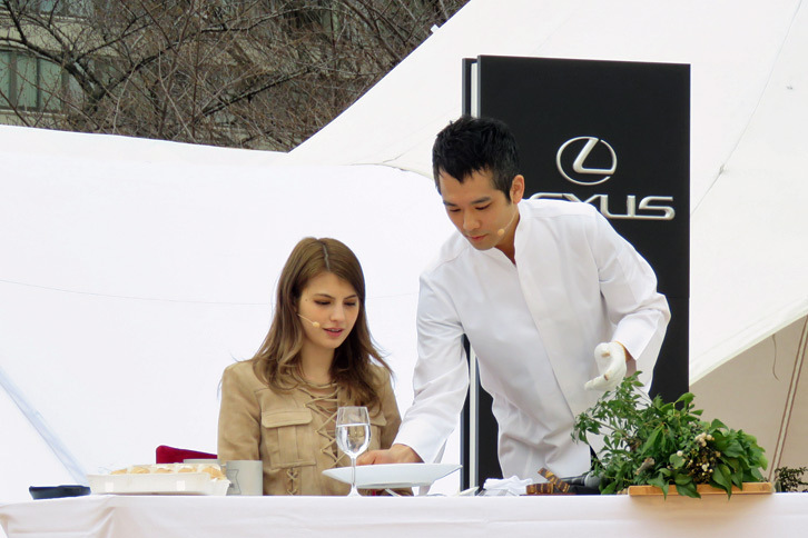 
	コーヒーを入れた後は、昼食会で提供されるオリジナルメニューを試食するマギーさん。写真右は、SUGALABOの須賀洋介氏。
	