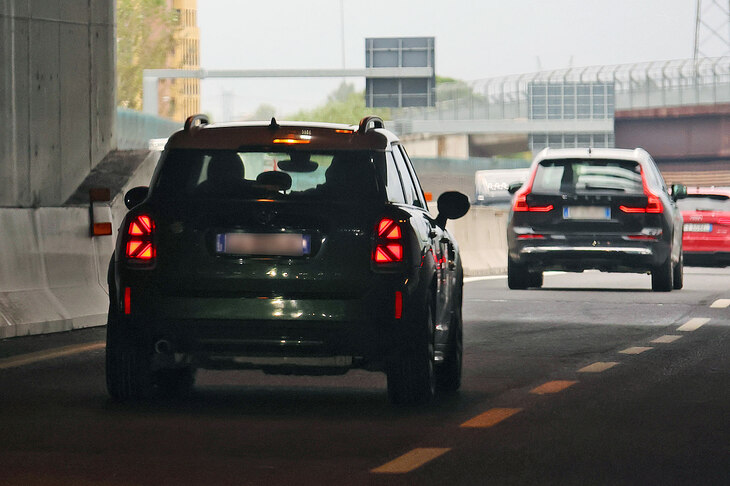 ユニオンジャック型テールランプを光らせる「MINI」。前方にはボルボが。2023年10月撮影。